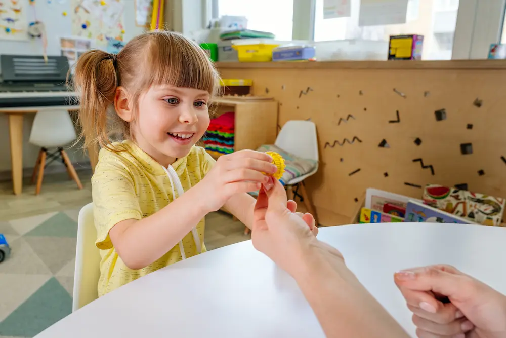 Girl on the lesson of the development of fine motor skills in kindergarten