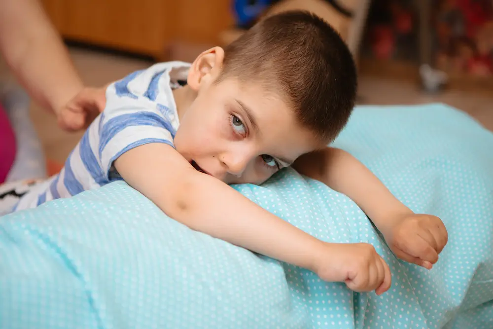 little kid with cerebral palsy has musculoskeletal therapy by doing exercises in body fixing